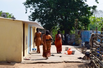 Women walk outside of their tiny homes in Wajalabad, one of the most impoverished colonies Rising Star supports.